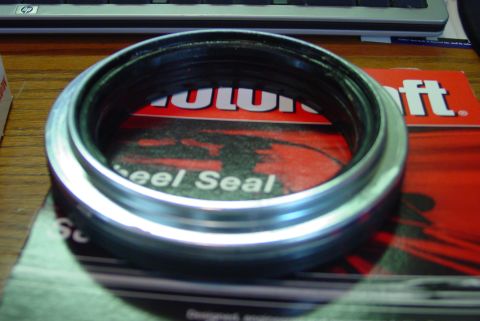 1993 Ford Bronco - A close-up view of a metal and rubber wheel seal resting on packaging.