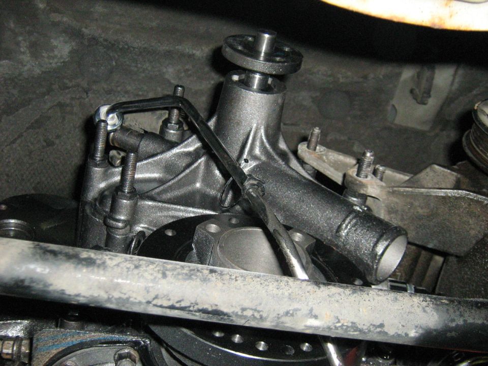 Close-up of an engine water pump housing and mounting brackets
