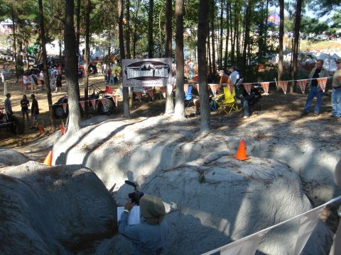 2002 Jeep Wrangler - Spectators watch an off-road event with a Diamond Axle banner and multiple vehicles in the background.