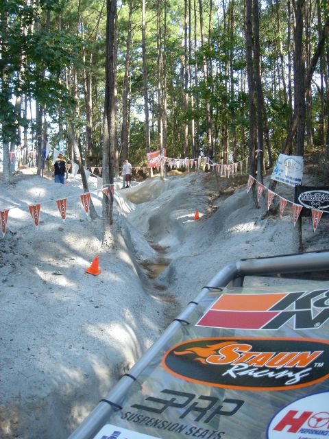 2002 Jeep Wrangler - A challenging off-road course winds through a wooded area, marked by flags and orange cones.