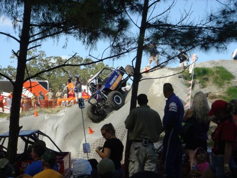 2002 Jeep Wrangler - Off-road buggy competition with spectators watching the action on a challenging course.