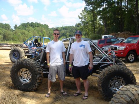 2002 Jeep Wrangler - Two men pose with a custom off-road buggy, with another similar vehicle visible behind them.