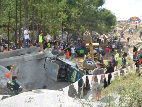 2002 Jeep Wrangler - An off-road vehicle is stuck on its side during a competition, with a crowd watching the action.