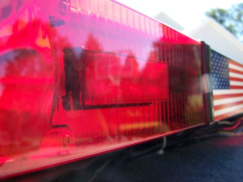 2003 Ford Crown Victoria - Red taillight assembly with an American flag sticker. Wires are visible.