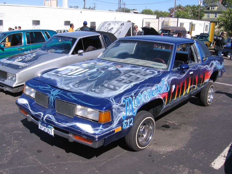 Blue coupe with airbrushed graphics on hood and sides, lowered stance