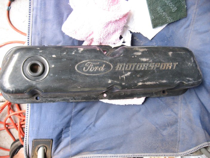 Worn black Ford Motorsport valve cover lying on a moving blanket