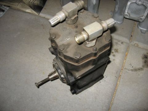 1978 Ford Bronco - This part is an on-board air compressor, likely for a vehicle's air system. It features two threaded fittings and a drive shaft.