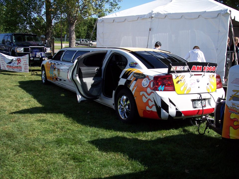 White limousine with racing flames and checkered flag graphics, rear view