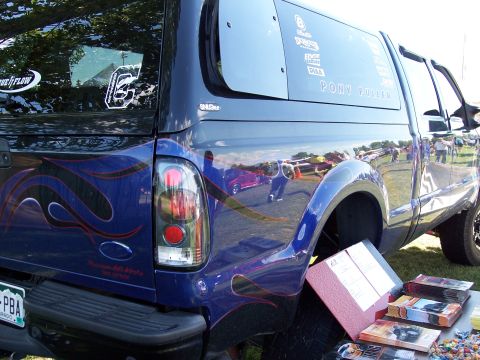 1972 Ford Ranchero - A customized blue pickup truck is parked on grass, with several brochures and candy on a table nearby.
