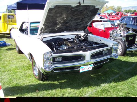 1972 Ford Ranchero - A white 1966 Pontiac GTO is displayed with its hood open, revealing the engine and GTO badging.