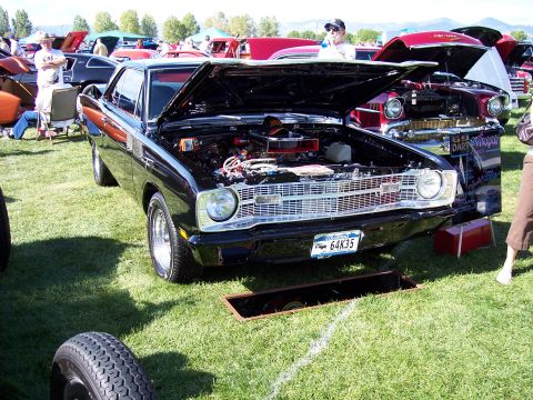 1972 Ford Ranchero - A black 1969 Dodge Dart is displayed with its hood open at an outdoor car show.