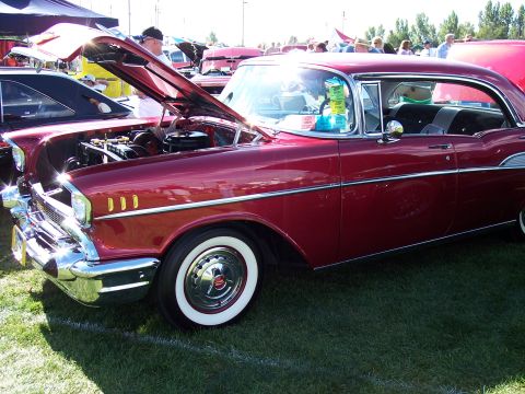 1972 Ford Ranchero - A classic red Chevrolet Bel Air is displayed with its hood up at an outdoor car show.