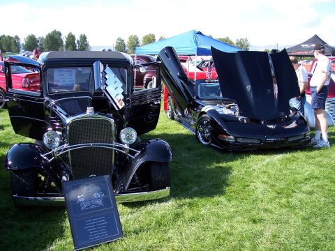 1972 Ford Ranchero - Two cars, a vintage model and a modern sports car, are displayed with their doors and hoods open on a sunny day.