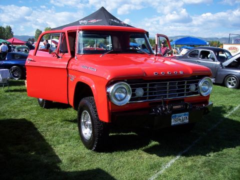 1972 Ford Ranchero - A bright red 1961 Dodge pickup truck is displayed on a grassy field with its doors open.