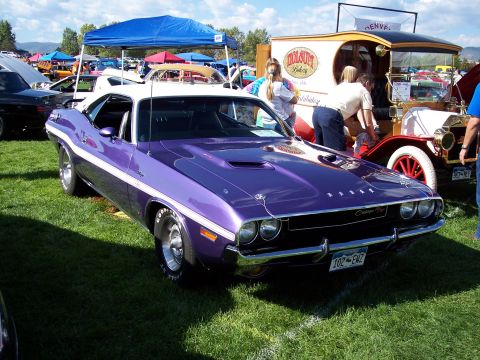 1972 Ford Ranchero - A purple Dodge Challenger is parked on the grass at an outdoor car show.