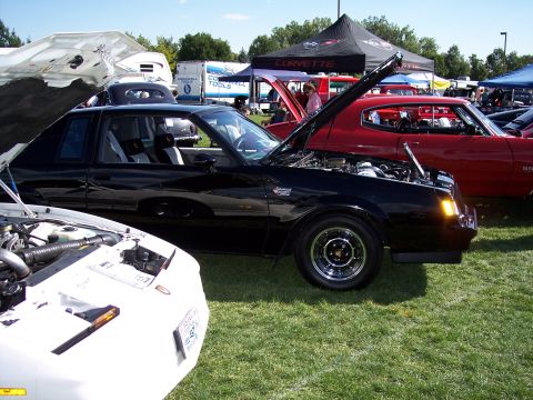 1972 Ford Ranchero - A black coupe with its hood open sits on grass at an outdoor car show.