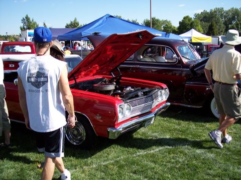 1972 Ford Ranchero - A red 1965 Chevelle Malibu is displayed with its hood open at an outdoor car show.