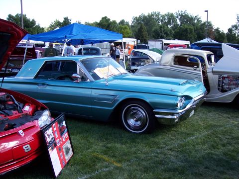 1972 Ford Ranchero - A classic teal Ford Thunderbird is displayed at an outdoor car show with other vehicles.