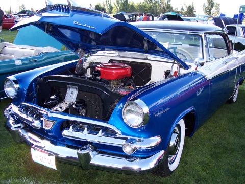 1972 Ford Ranchero - A classic Dodge Custom Royal with its engine exposed is displayed at an outdoor car show.