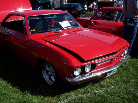 1972 Ford Ranchero - A bright red 1965 Chevrolet Corvair coupe is displayed with its hood open at an outdoor car show.