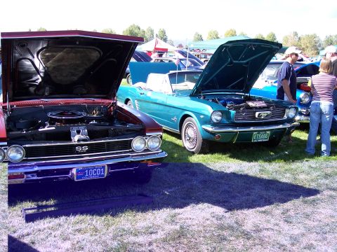 1972 Ford Ranchero - Two vintage cars are displayed with their hoods open at an outdoor car show.