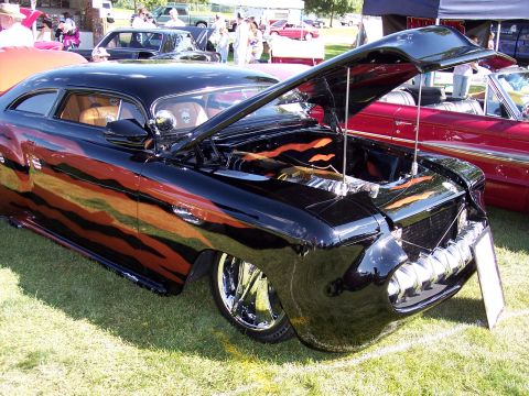 1972 Ford Ranchero - Custom hot rod with flame paint and open hood on display at an outdoor car show.