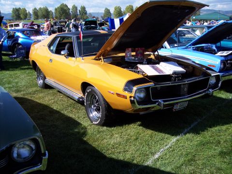 1972 Ford Ranchero - A yellow 1970 AMC Javelin AMX is displayed with its hood open at a car show, alongside other vehicles.