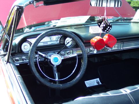 1972 Ford Ranchero - The interior of a classic car features a large steering wheel, dashboard gauges, and a pair of red fuzzy dice hanging from the rearview mir…