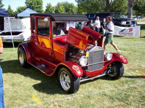 1972 Ford Ranchero - A vintage red coupe with its hood open, revealing the engine, sits on display at an outdoor event.