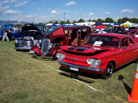 1972 Ford Ranchero - A red 1965 Chevrolet Corvair Monza is displayed at an outdoor car show with other vehicles.