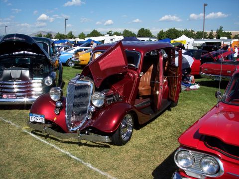 1972 Ford Ranchero - A customized vintage sedan is displayed with its hood and doors open at an outdoor car show.
