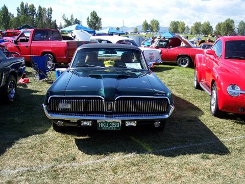 1972 Ford Ranchero - A green 1969 Mercury Cougar is displayed at an outdoor car show, with other vehicles visible in the background.