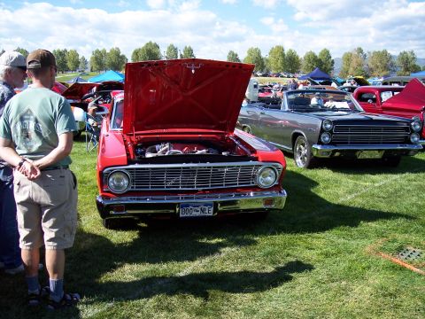 1972 Ford Ranchero - A red 1964 Ford Falcon is displayed with its hood up at an outdoor car show.