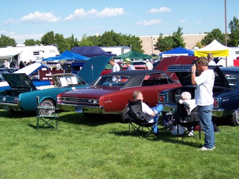 1972 Ford Ranchero - Several classic automobiles are displayed on a sunny day at an outdoor car show event.