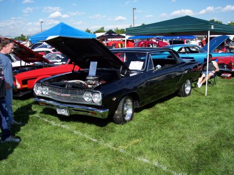 1972 Ford Ranchero - A black 1966 Chevrolet Chevelle Malibu is displayed at an outdoor car show with its hood open.