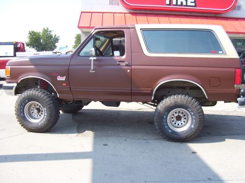 1990 Ford Bronco - This lifted 1987 Ford Bronco features large off-road tires and a two-tone paint scheme.