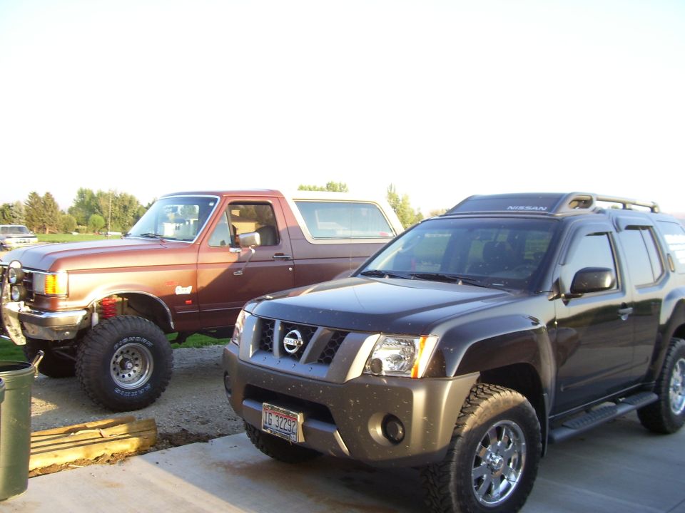 1990 Ford Bronco and a dark Nissan Xterra parked outdoors