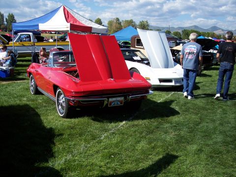 1972 Ford Ranchero - A red convertible sports car is displayed with its hood open at an outdoor car show.