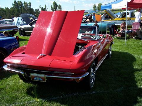 1972 Ford Ranchero - A red convertible sports car is displayed with its hood open at an outdoor event.