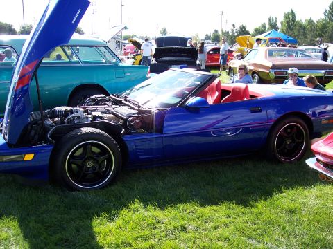 1972 Ford Ranchero - A blue convertible is displayed with its hood open at an outdoor car show, revealing the engine and red interior.