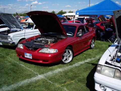1972 Ford Ranchero - A red Ford Mustang from the mid-1990s is displayed with its hood open at an outdoor car show.