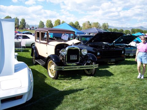 1972 Ford Ranchero - A cream and black 1928 Ford Model A sedan is displayed at an outdoor car show.