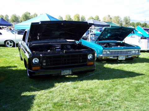 1972 Ford Ranchero - Two classic trucks are parked on grass with their hoods open at an outdoor car show.