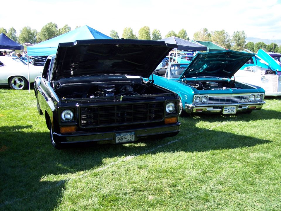 Black pickup truck with hood open, grille visible, license plate 646-LBT
