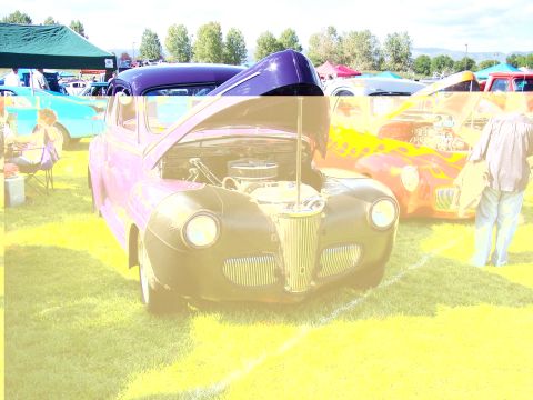 1972 Ford Ranchero - Two vintage cars are displayed on a grassy field under a bright sky.