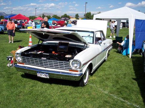 1972 Ford Ranchero - A white 1966 Chevrolet Nova is displayed with its hood open at a car show.