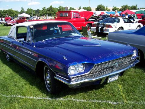 1972 Ford Ranchero - A blue 1965 Ford Thunderbird convertible with a white vinyl top is displayed at an outdoor car show.
