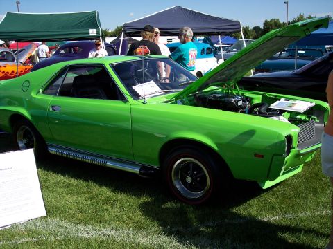 1972 Ford Ranchero - This lime green muscle car is displayed with its hood open, revealing the engine and a red stripe on its wheels.