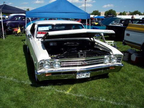 1972 Ford Ranchero - A white coupe with its hood open at an outdoor car show, displaying 'SS' badging on the grille.
