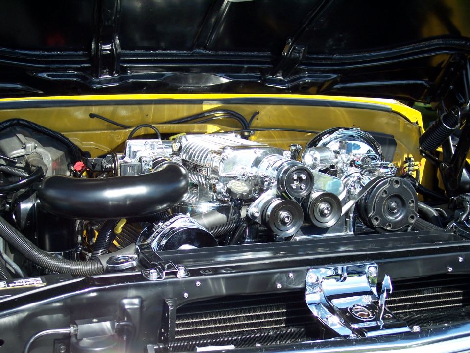 Chrome supercharger and pulleys on a V8 engine, yellow engine bay